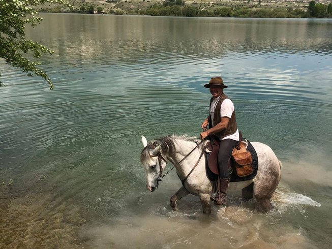 man riding horse in cappadocia lake