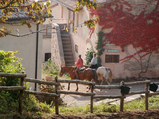 People riding horses in a village in tuscany