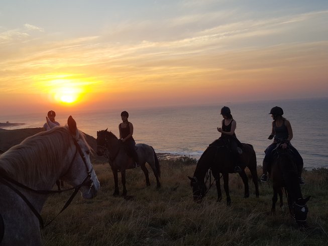 horse riders at sunset